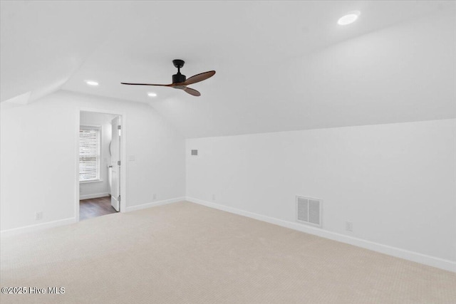 additional living space featuring lofted ceiling, light carpet, and ceiling fan