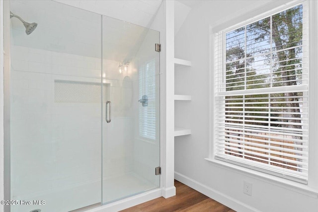 bathroom with an enclosed shower and hardwood / wood-style floors