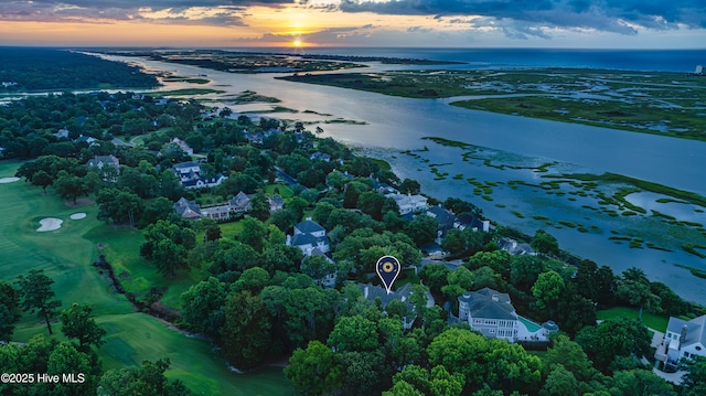 aerial view at dusk featuring a water view