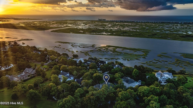 aerial view at dusk featuring a water view