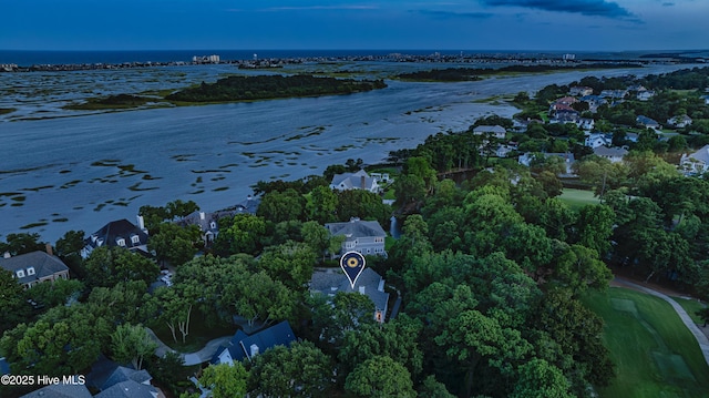 aerial view at dusk featuring a water view