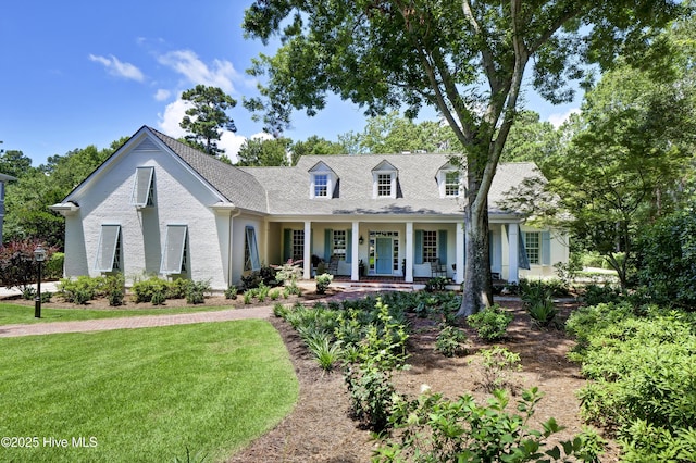 new england style home with a porch and a front yard