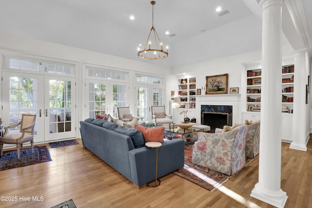 living room with french doors, a premium fireplace, decorative columns, and hardwood / wood-style floors