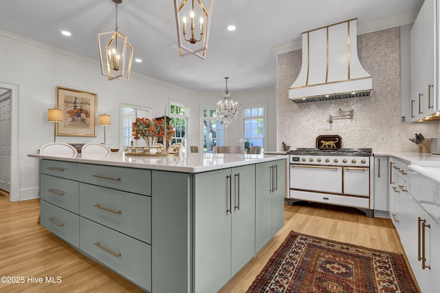 kitchen featuring double oven range, custom exhaust hood, hanging light fixtures, and a chandelier