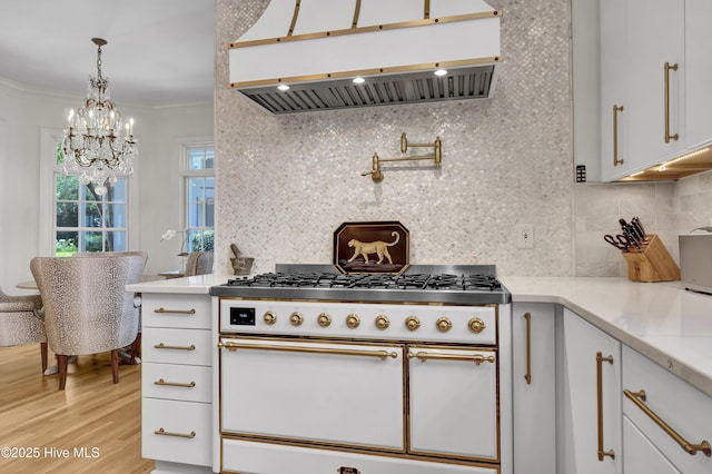 kitchen with white cabinetry, hanging light fixtures, ornamental molding, double oven range, and exhaust hood