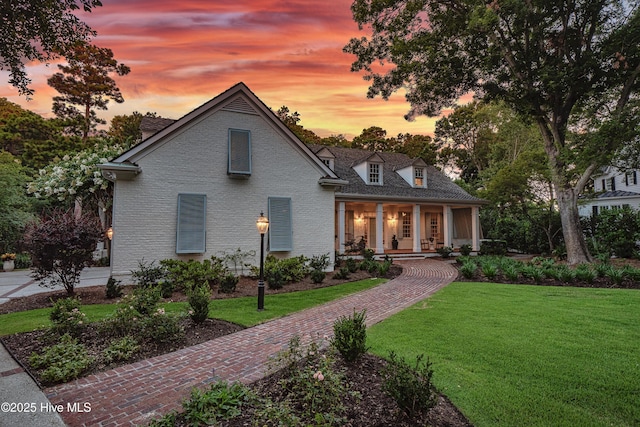 view of front facade with a lawn and a porch