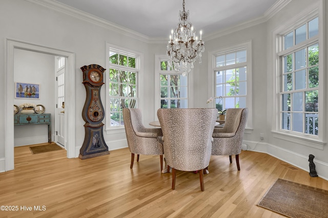 dining space featuring crown molding, a chandelier, and light wood-type flooring