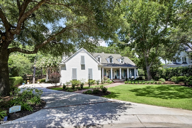 cape cod home featuring covered porch and a front yard