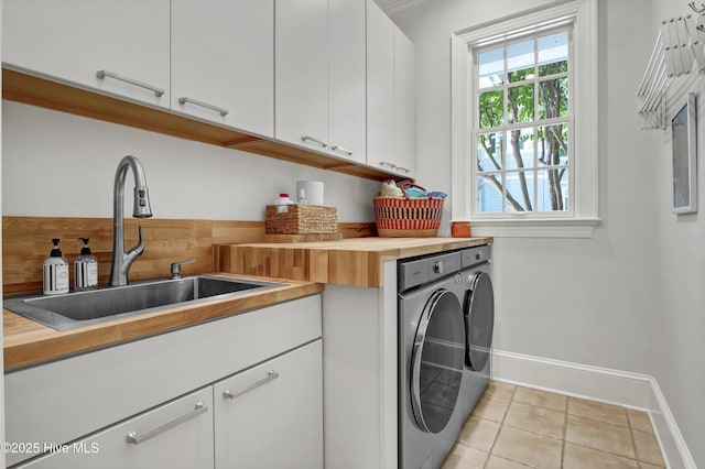 laundry area with cabinets, sink, light tile patterned floors, and independent washer and dryer