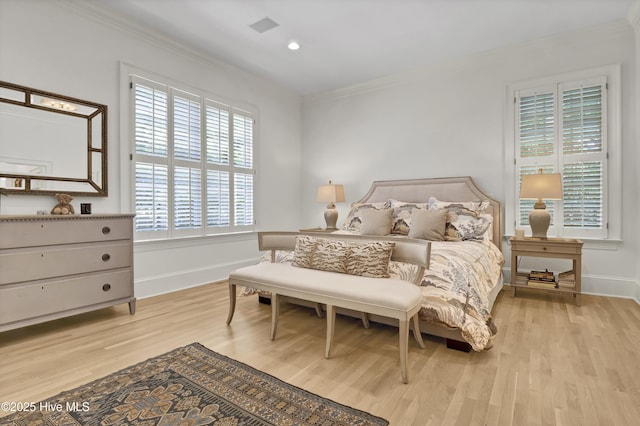 bedroom featuring ornamental molding and light hardwood / wood-style floors