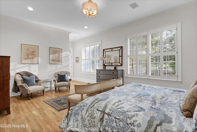 bedroom with crown molding and light hardwood / wood-style flooring