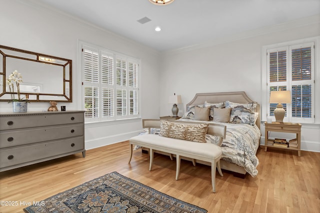 bedroom with ornamental molding and light wood-type flooring