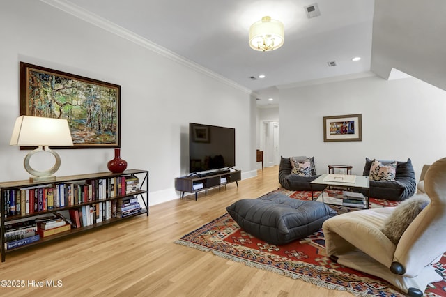 living room with ornamental molding and light wood-type flooring