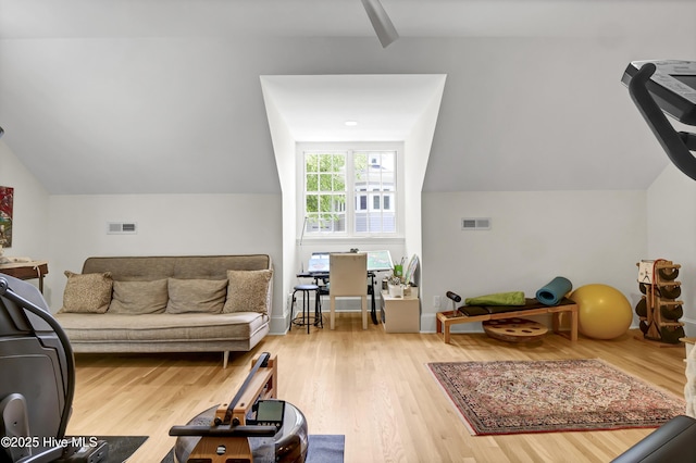 exercise room featuring wood-type flooring and vaulted ceiling