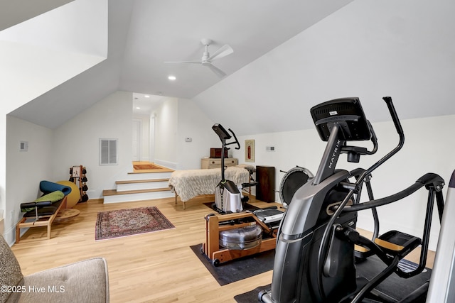 workout room with hardwood / wood-style flooring, ceiling fan, and vaulted ceiling