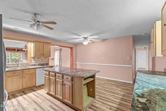 kitchen with dishwasher, a center island, sink, and light hardwood / wood-style flooring