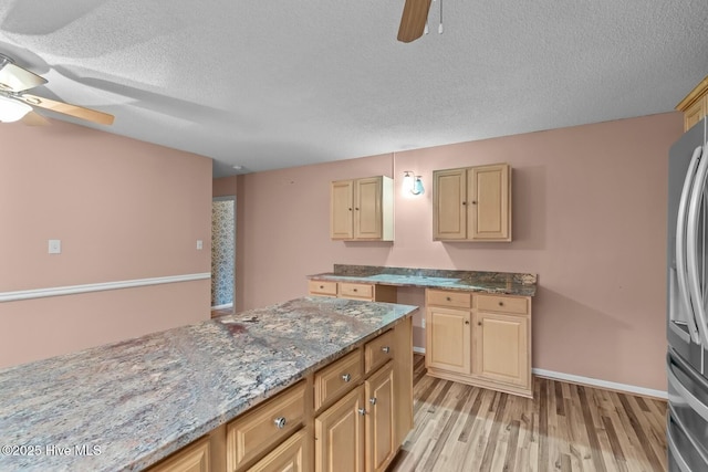 kitchen featuring stone counters, a textured ceiling, ceiling fan, and light hardwood / wood-style flooring