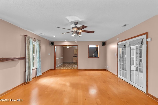 unfurnished room with ceiling fan, a textured ceiling, and light hardwood / wood-style floors