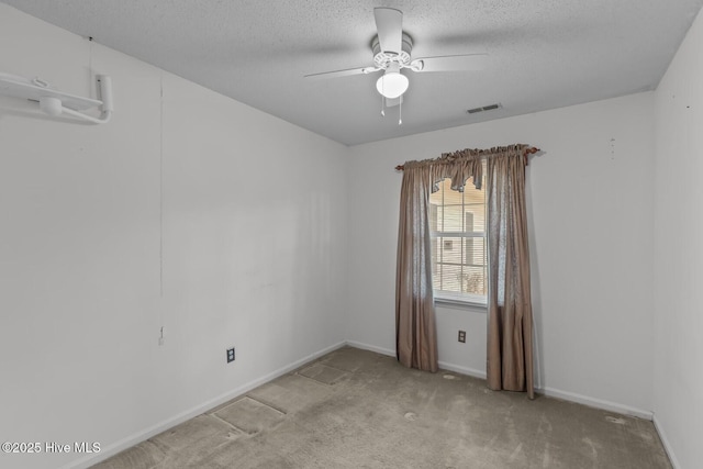 carpeted spare room with a textured ceiling and ceiling fan