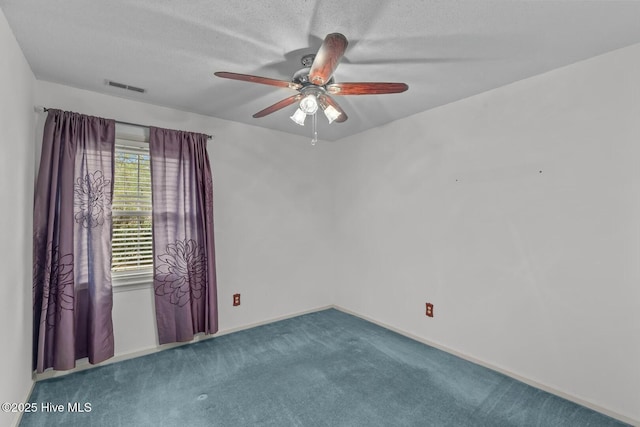 empty room featuring ceiling fan, a textured ceiling, and carpet