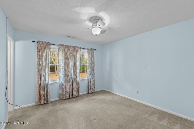 spare room featuring ceiling fan, carpet, and a textured ceiling