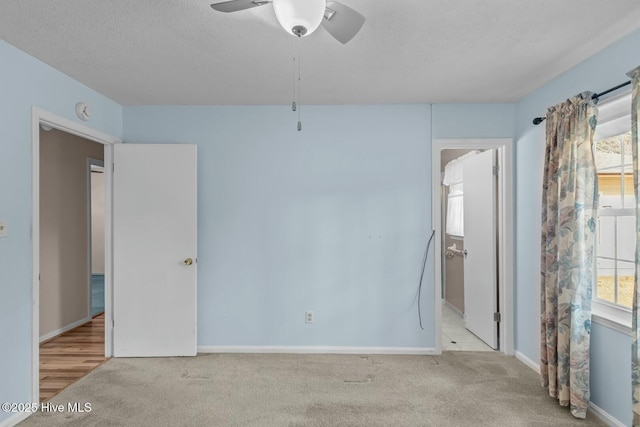 carpeted empty room with ceiling fan and a textured ceiling