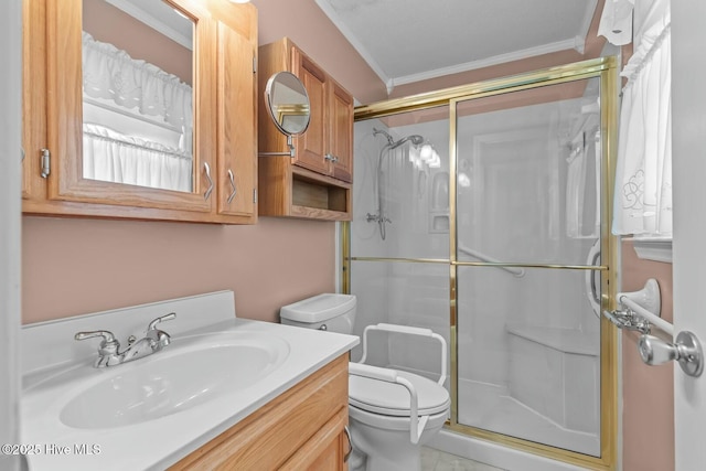 bathroom featuring vanity, a shower with shower door, ornamental molding, and toilet