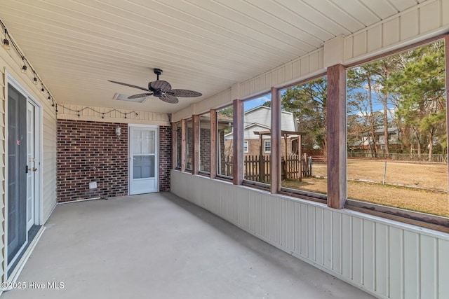 unfurnished sunroom featuring ceiling fan and a healthy amount of sunlight