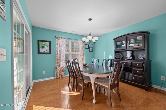 dining space with hardwood / wood-style flooring and a chandelier