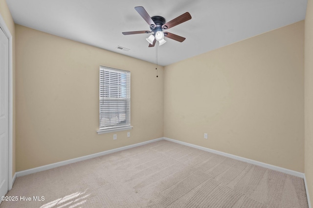 carpeted spare room featuring ceiling fan