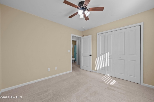 unfurnished bedroom with light colored carpet, ceiling fan, and a closet