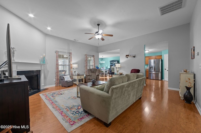 living room with ceiling fan and light hardwood / wood-style floors