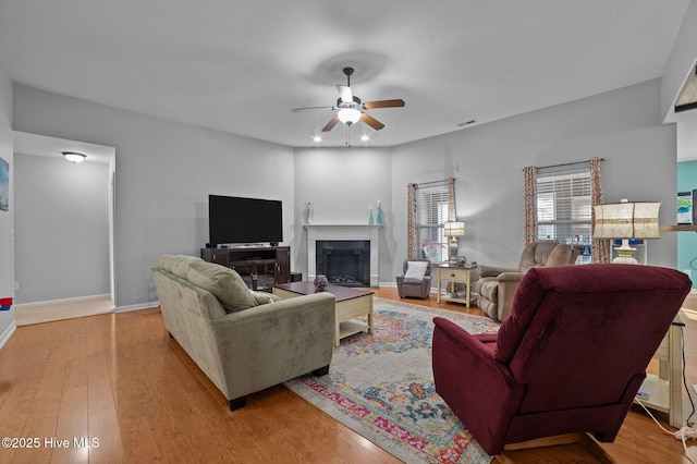 living room with light hardwood / wood-style flooring and ceiling fan