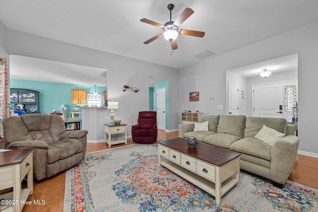 living room with ceiling fan and light hardwood / wood-style floors