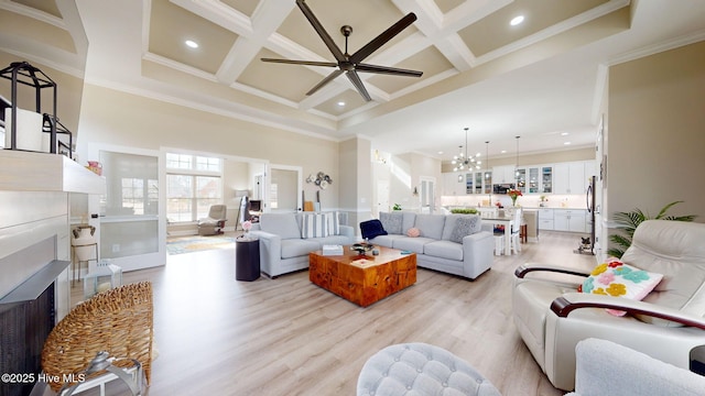 living room with coffered ceiling, a towering ceiling, beam ceiling, and light hardwood / wood-style floors