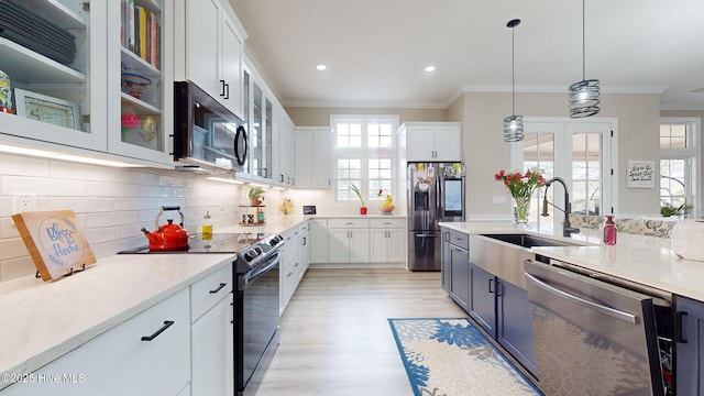 kitchen featuring white cabinetry, decorative light fixtures, and appliances with stainless steel finishes