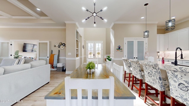 dining area with french doors, ornamental molding, and light wood-type flooring