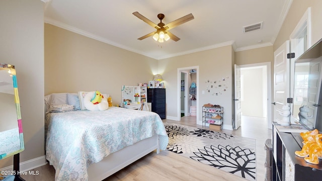 bedroom featuring crown molding, light hardwood / wood-style floors, and ceiling fan