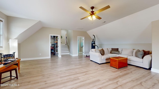 living room with light hardwood / wood-style flooring, ceiling fan, and vaulted ceiling