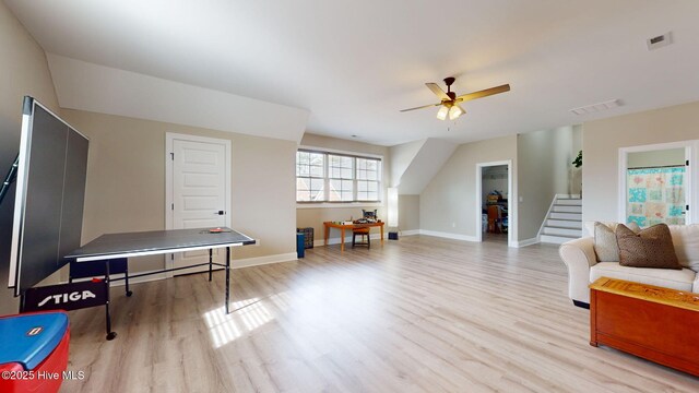 living room featuring vaulted ceiling, ceiling fan, and light wood-type flooring