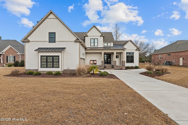 modern farmhouse featuring a porch and a front lawn