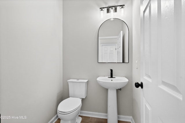 bathroom with toilet and hardwood / wood-style floors