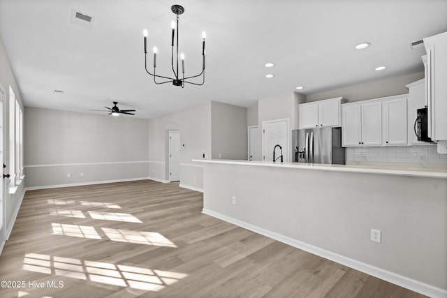 kitchen with light hardwood / wood-style flooring, stainless steel refrigerator with ice dispenser, sink, backsplash, and white cabinets