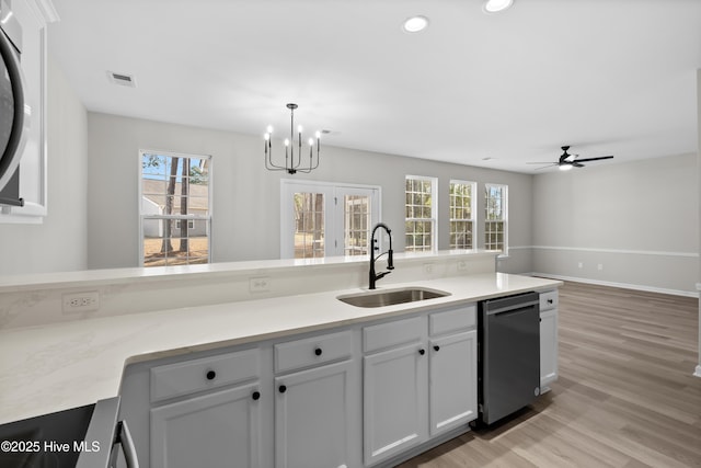 kitchen featuring light hardwood / wood-style floors, sink, dishwasher, white cabinets, and pendant lighting