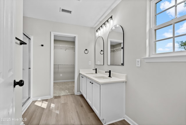 bathroom featuring hardwood / wood-style flooring, vanity, and walk in shower