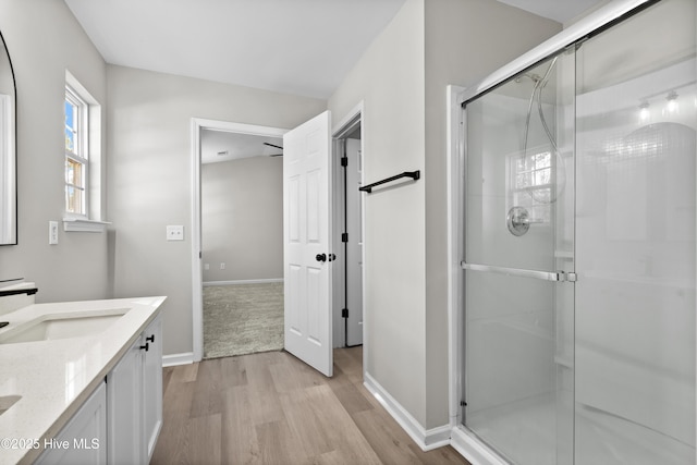 bathroom featuring vanity, a shower with shower door, and wood-type flooring