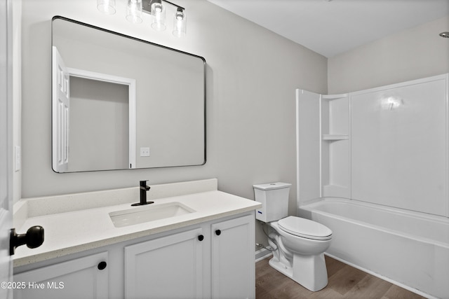 full bathroom featuring hardwood / wood-style floors, toilet, shower / bathing tub combination, and vanity