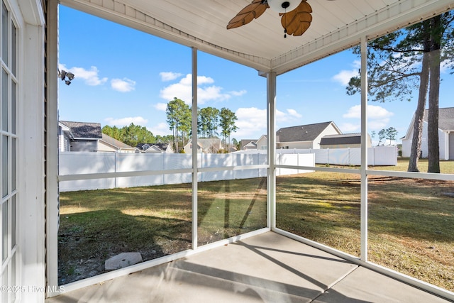 unfurnished sunroom with a wealth of natural light and ceiling fan