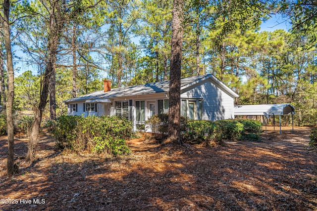 view of front of home with a carport and a chimney