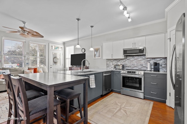 kitchen featuring decorative light fixtures, white cabinetry, sink, gray cabinetry, and stainless steel appliances